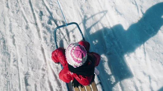 小女孩的顶部视野儿童在冬季公园雪雪地滑雪生活方式跟踪视频