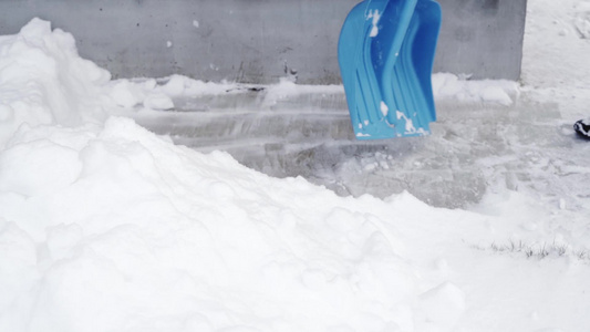 蓝色雪铲布在破雪背景的白雪下视频