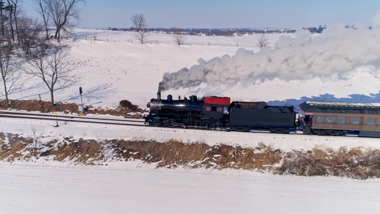 看到古老的蒸汽机车逼近拉着客车在暴风雪后吹起烟雾和视频