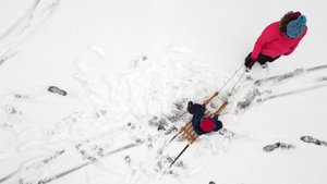 母亲在雪地上用雪橇拉着孩子17秒视频