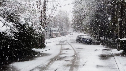 街道上落下的雪花沥青路上的清雪上的脚印和轮胎足迹视频