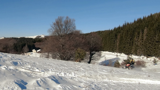 运动黄色雪地摩托在慢动作中跳跃雪地摩托轨道下的雪尘云视频