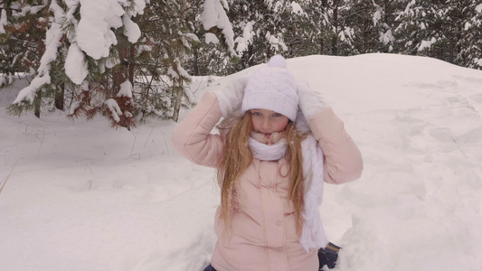 快乐的少女在冬季森林中下雪在愚昧的树林背景视频