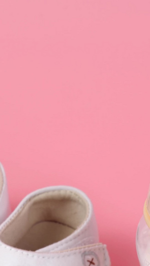 粉色背景婴儿鞋和小奶瓶可爱组合婴儿用品19秒视频