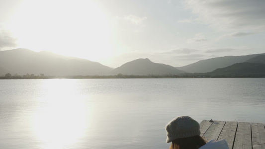 网际自由职业选择概念一名年轻妇女在日落时坐在湖边的视频