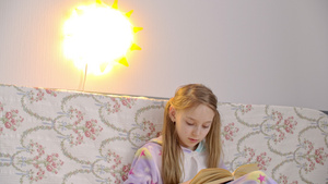 穿着睡衣的少女在卧室里用夜灯灯笼看书放松16秒视频