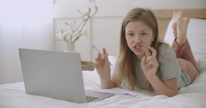 少女躺在床上用笔记本电脑做功课11秒视频