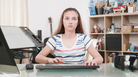 一个十几岁女孩在电脑上打短信的肖像视频