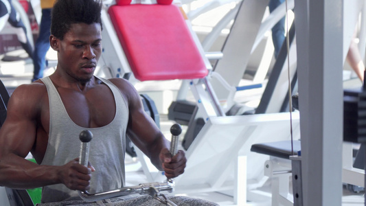 在低排有线健身机上工作的非洲年轻人被撕裂视频