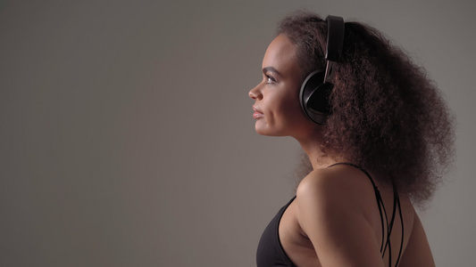 非洲裔美国女孩戴着耳机抬头听音乐闭上眼睛享受孤立在视频