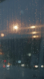 雨季夜晚公交车站台玻璃水珠下班高峰视频