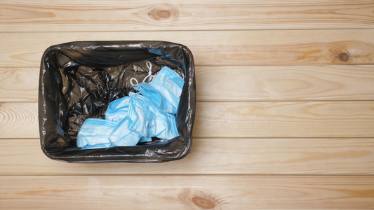 垃圾掩码到垃圾箱浪费医疗废物废弃的外科口罩垃圾桶视频