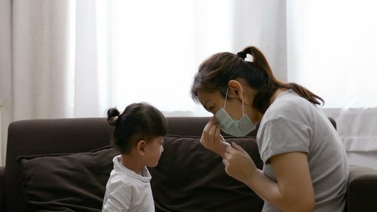 为女儿戴面罩以防止的亚洲母亲身着视频