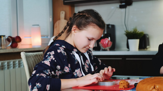 快乐的年轻女孩用糕点面粉来填烤盘子视频