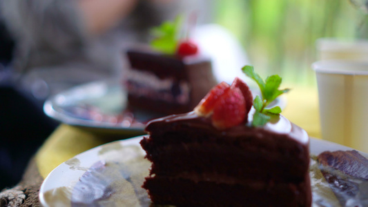 咖啡馆有樱桃的巧克力蛋糕聚焦于前景4k视频