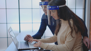 有面罩夫妇工人一起工作在办公用笔记本电脑时使用白天24秒视频