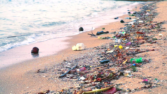 海上日落塑料橡胶和废物留在海滩上海浪将它们吹入海中视频
