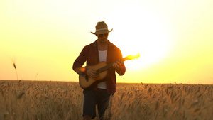 年轻人在日落的光线下走着金麦田弹吉他自由的概念11秒视频