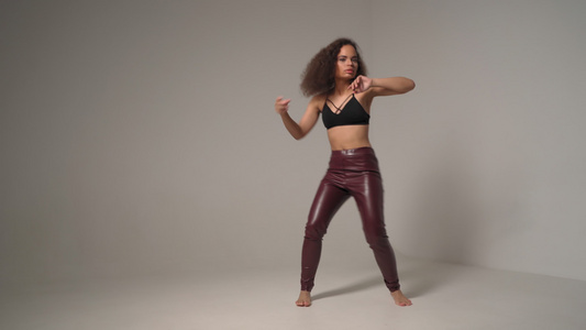跳舞的年轻非洲裔美国女孩穿着黑色上衣和皮裤双手在空中视频