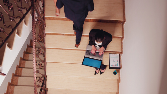 女性在办公室楼梯上用笔记本电脑超负荷工作视频
