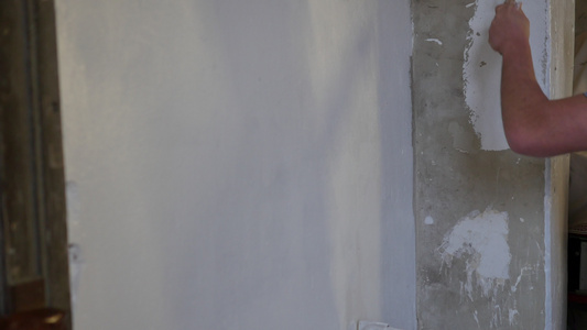 画家人画墙的侧面图用油漆滚筒和桶在大空地上男人视频