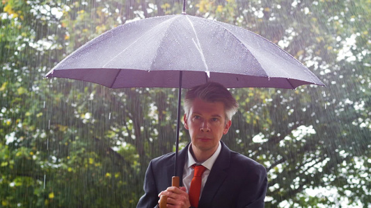 男性白领躲在雨伞下避雨视频