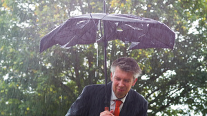 在雨中躲在破碎的雨伞下被遮盖着的商人17秒视频