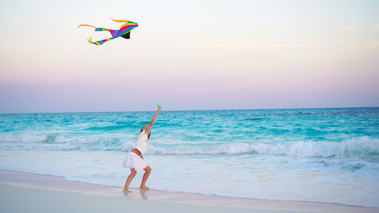 可爱的小女孩在热带海滩上放风筝孩子在海边玩着美丽的视频