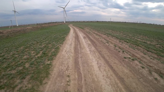 骑自行车沿风车行驶在一条灰尘小路上行驶视频