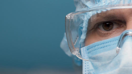 个人防护服和护目镜的肖像员工实验室专注的医生的眼睛视频
