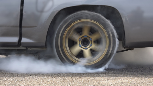 赛车拖动汽车在准备比赛时将橡胶从轮胎上烧掉视频