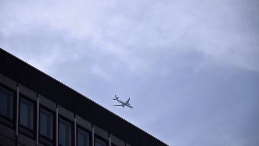 商业喷气式喷气飞机低空飞越隆登大楼上空飞行中视频