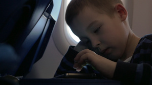 坐在飞机上坐着一个小男孩在手机上玩游戏17秒视频