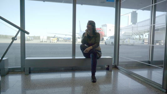 机场的年轻旅游女青年在飞机上透过窗户看一看视频