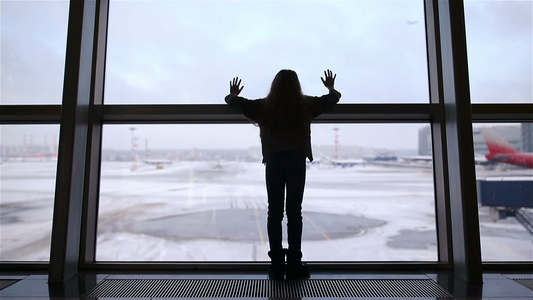 在机场靠近大窗户的小女孩在等待登机时等候登机视频