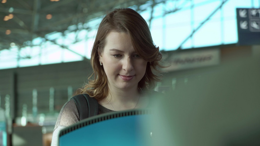 自助中转区的年轻女性在机场航站楼带触摸屏的自动化机器视频