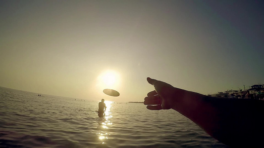 日落时在海滩玩飞盘的人慢动作第一视角视频