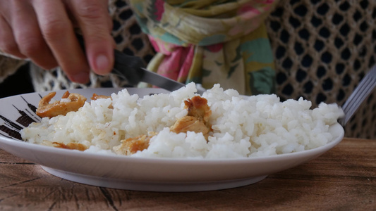 手紧的女子手握着叉子和米饭以及盘子里的肉视频