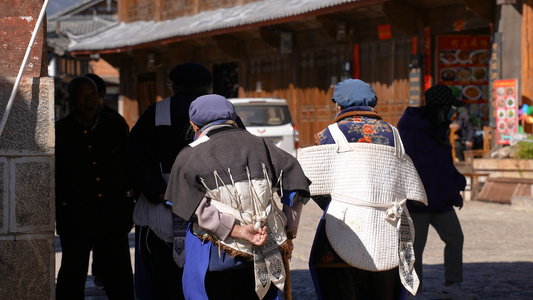 云南旅游丽江古城穿纳西族服饰的本地人背影4k素材视频