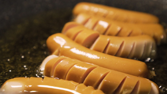 香肠在满锅油上被炸焦了快速食物热量慢动视频