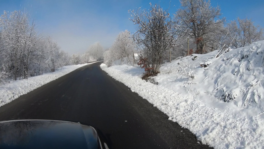 冬季下雪时在空路上行驶风雪覆盖地貌的雪覆盖风景视频