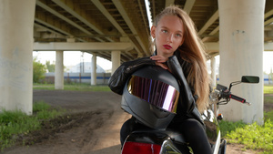 骑摩托车的女孩戴着摩托车头盔坐在城市汽车桥下的摩托车10秒视频