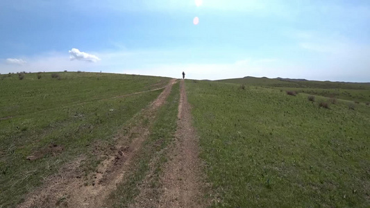 在绿地的路上骑着自行车视频