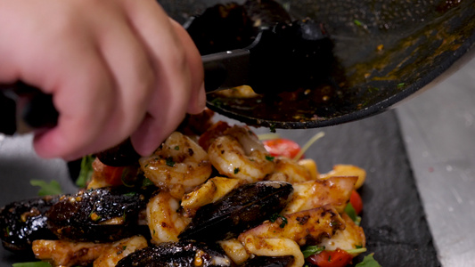 厨师和手拿钳子的厨师把煮熟的海鲜放在手里视频