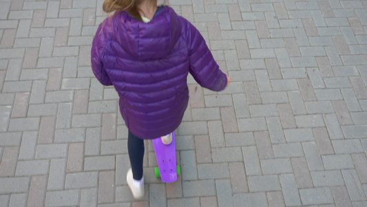 年轻的少女骑在城市街道铺好的人行道上的滑板上女孩少年视频