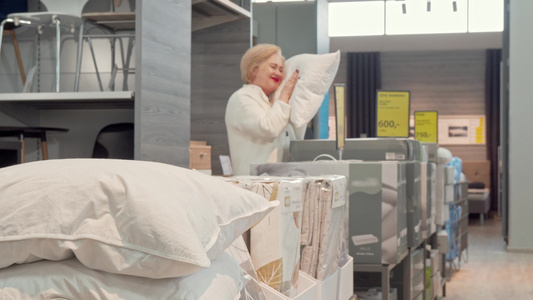 在家具商店选择新整形枕头的高级女顾客妇女视频