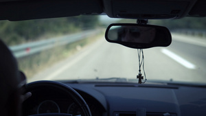 在一辆高速公路上驾驶的秃头驾驶者的后视镜上15秒视频