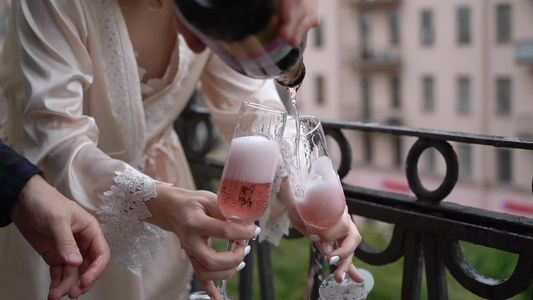 年轻夫妇开瓶香槟在阳台上倒杯子酒精饮料和喝的酒请喝酒视频