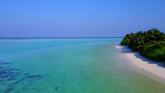 以蓝环礁湖和清洁沙地背景进行热带海岸海滩航行的无人驾驶视频