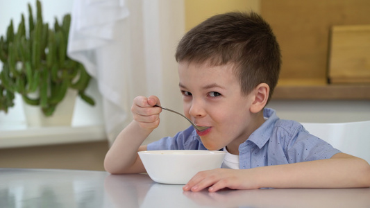 儿童独自坐在厨房桌旁在饭桌上吃着甜玉米片和牛奶的小男孩视频